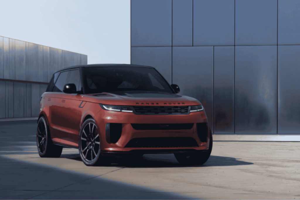 Range Rover Sport rojo estacionado frente a fachada de vidrio y acero moderna